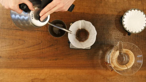Elden damlayan kahve, barista filtreli kahve zeminine su döker.