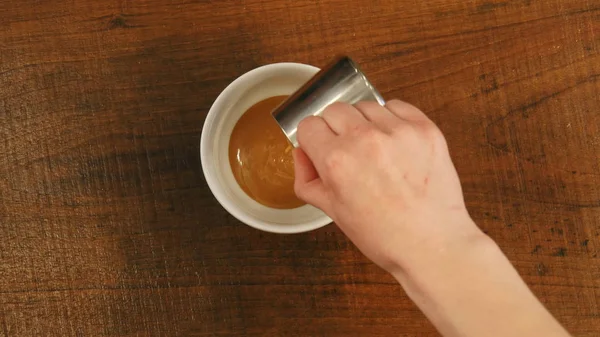 Бариста наливает карамельный сироп в чашку. — стоковое фото