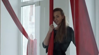 Hava bir kumaş yakın duran ve kameraya, arayan genç kadın direk dansör gülümseyen