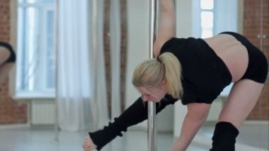 Bir stüdyoda çalışan güzel genç pole dancer kadın