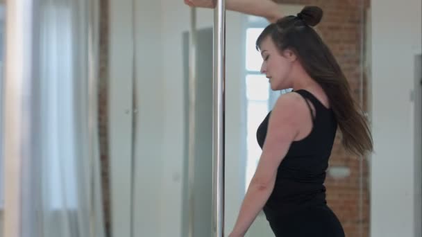 Jeune danseuse de pôle portant l'entraînement de vêtements de sport balck et regardant la caméra — Video