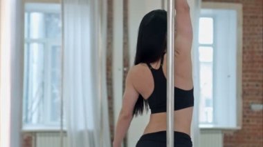 Güzel kadın kutup dans stüdyosunda gerçekleştirme