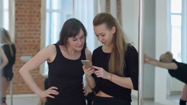 Lindos bailarines de polo feliz tomando un descanso de su entrenamiento y redes sociales con un teléfono celular — Vídeo de stock