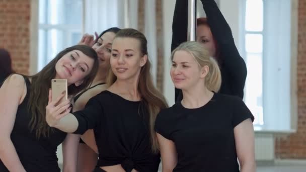 Grupo de hermosas mujeres jóvenes tomando una selfie durante un descanso en una clase de fitness polo — Vídeos de Stock