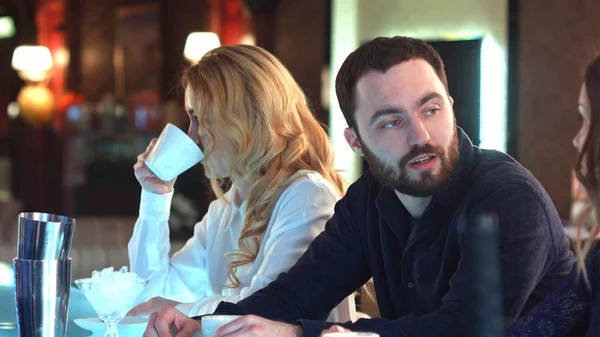 Gente feliz socializando y cotilleando sobre bebidas en un ambiente relajado en un bar — Foto de Stock