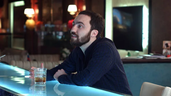 Un joven en un bar conversando con un camarero y bebiendo — Foto de Stock