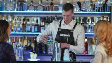 Barmen kokteyl bar sayacı iki kız için yapıyor