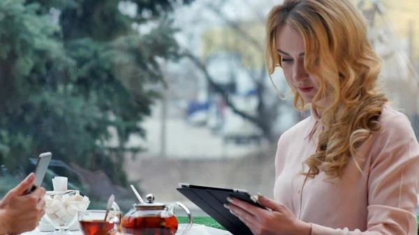 Meninas usam sua pausa do trabalho para beber café, conversar e usar tablet digital — Fotografia de Stock