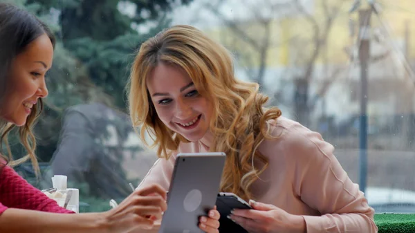 Jóvenes hermosas mujeres felices utilizando tableta en la cafetería — Foto de Stock