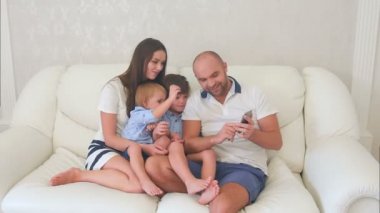 Mutlu anne ve telefonda fotoğraflarına bakmaktan küçük oğlu