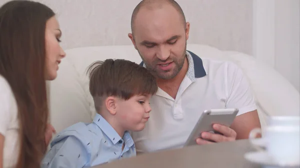 Eşi ve oğlu için bir şeyler tablet üzerinde gösterilen genç Baba — Stok fotoğraf