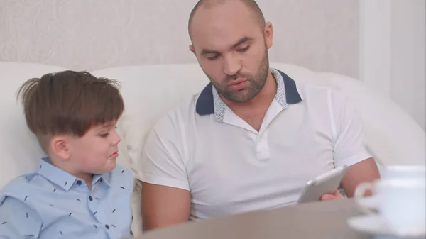 Ojciec i syn korzystający z tabletu cyfrowego na sofie w domu — Zdjęcie stockowe