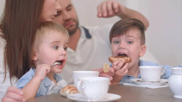 İki küçük çocuk çocuklar ebeveynleri ile birlikte pasta ile çay içiyor — Stok fotoğraf