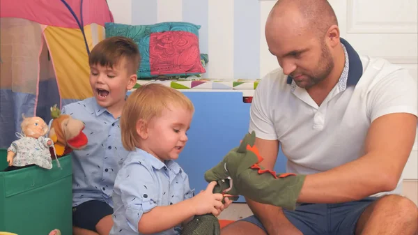 Happy parents and two little boys playing with puppets — Stock Photo, Image