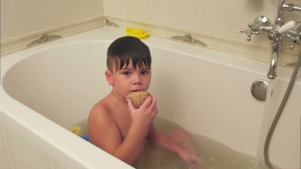 Menino brincando com a concha enquanto toma banho na banheira — Vídeo de Stock