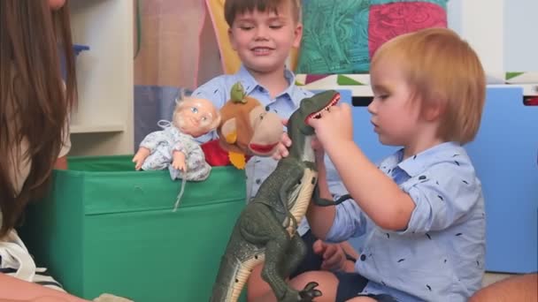 Двоє хлопчиків грають з іграшками у своїй дитячій кімнаті — стокове відео