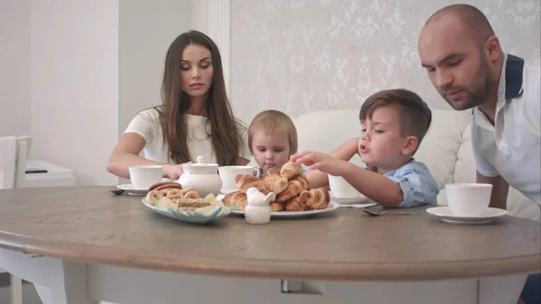 Mamá y papá se unen a sus hijos varones en la mesa del café —  Fotos de Stock