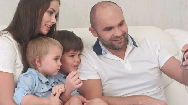 Familia feliz mirando sus fotos por teléfono —  Fotos de Stock