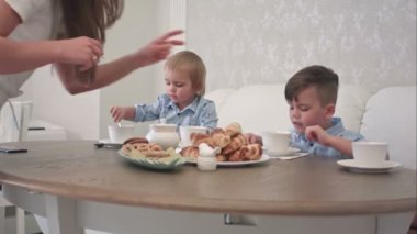 İki küçük çocuk masasında pasta ile çay içme