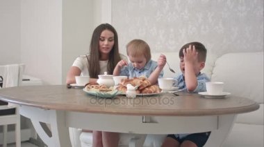 Genç anne evde çay olan küçük çocukları katılıyor