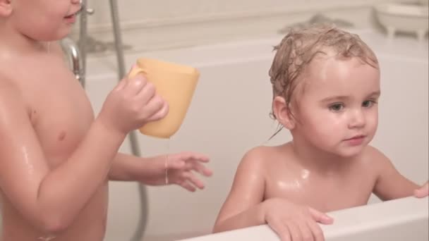 Старший брат моет младшего брата в ванной — стоковое видео