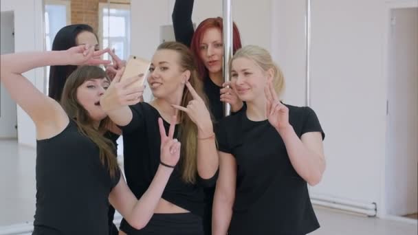 Group of beautiful young women taking a selfie with smartphone during a pole dance class — Stock Video