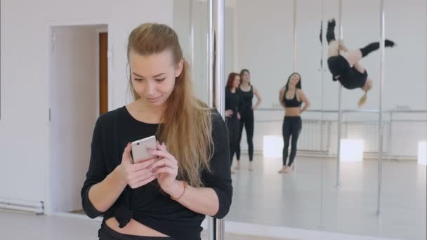 Schattig pool danser met behulp van mobiele telefoon tijdens een paal dansles — Stockvideo