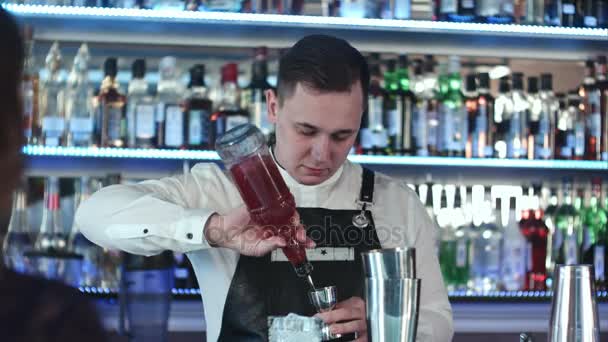 Giovane bel barman nel bar interno miscelazione cocktail di alcol — Video Stock