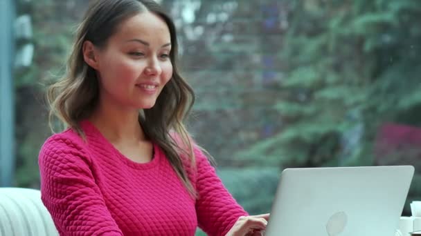 Gelukkig blonde vrouw met behulp van laptop met videoconferentie in café — Stockvideo