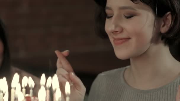 Ελκυστική κοπέλα είναι έτοιμος να κάνει μια ευχή και να φυσήξει όλα τα κεριά — Αρχείο Βίντεο