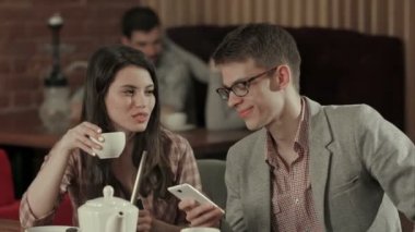 Genç sigara nargile çift ve smartphone kullanın