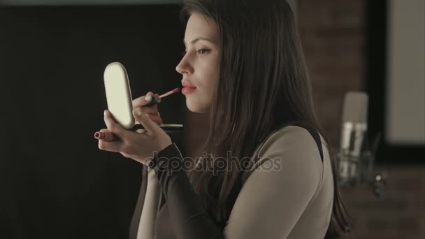 Bautiful joven cantante aplicando maquillaje de labios con cepillo cosmético — Vídeo de stock