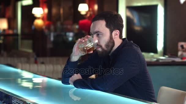 Przystojny facet zamyślony patrzy do przodu i myślenia, siedząc w barze licznik w pubie — Wideo stockowe