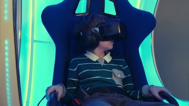 Αρσενικό παιδί στην καρέκλα εικονικής πραγματικότητας, απολαμβάνοντας την εμπειρία του — Αρχείο Βίντεο