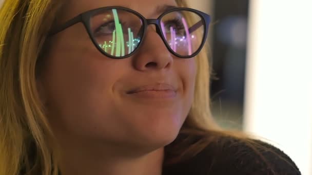 Chica joven en gafas de vista mirando las luces de la calle por la noche — Vídeo de stock