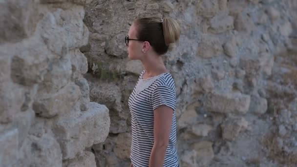 Молода красива жінка дивиться на стародавні руїни — стокове відео