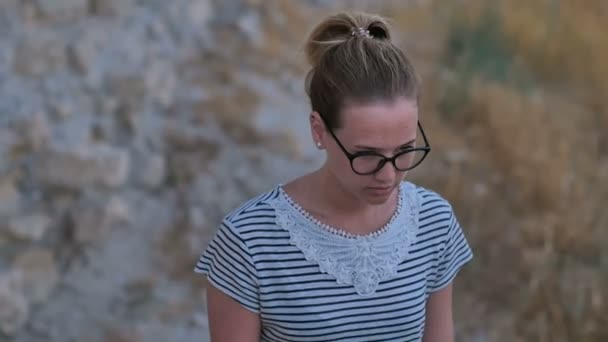Csinos lány séta a romok a háttérben szemüveg — Stock videók