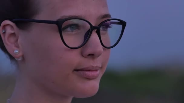 Mladá usměvavá žena v brýlích na zeleném pozadí — Stock video
