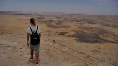 Dağ taş uçurumun kenarında yürüyen sırt çantası ile kadın turist