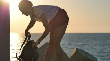 Kadın turistik sahil onun sırt çantası koyarak