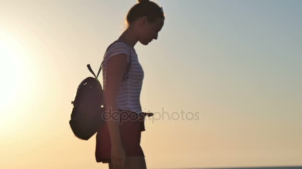 Mladá žena se těší nádherný západ slunce na pláži — Stock video