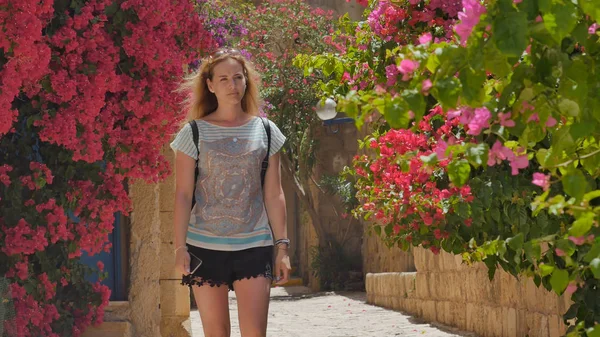 Tropikal şehirde eski cadde boyunca yürüyüş telefon olan kadın