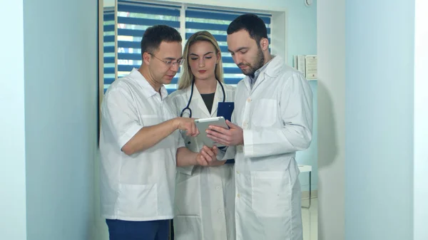 Αρσενικό ο γιατρός δείχνει κάτι σε tablet με τους συναδέλφους του — Φωτογραφία Αρχείου