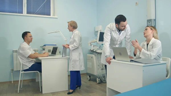 Médecins masculins et féminins discutant de cas médicaux au bureau — Photo