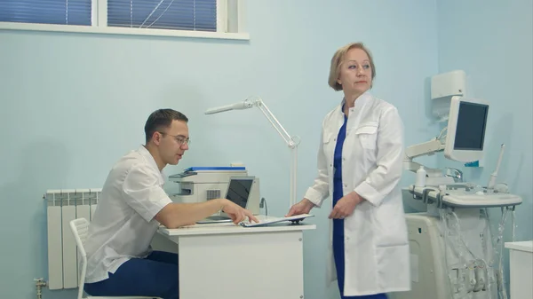 Senior medico femminile condividere le responsabilità tra team medico — Foto Stock