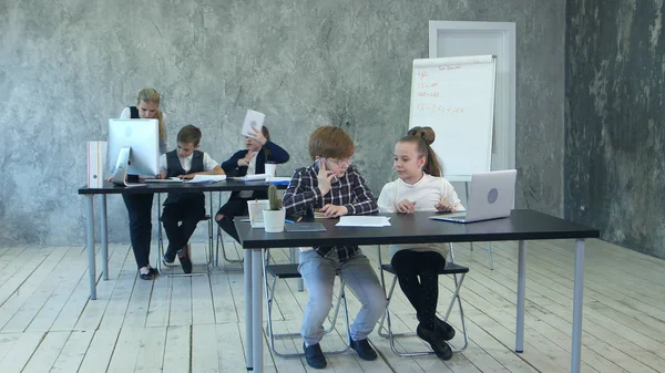 Grupo de niños de negocios compartiendo ideas, utilizando computadoras portátiles y tabletas, trabajando en la oficina — Foto de Stock