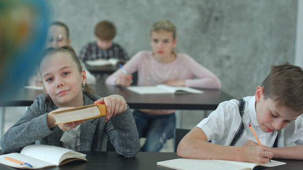 Teacher with kids in geography class looking at globe