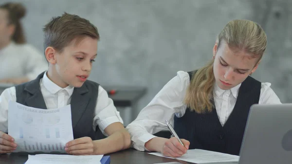 Niños de negocios que trabajan con documentos y con laptop — Foto de Stock