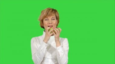 Yeşil ekranda Chroma anahtar yeşil elma yiyen genç kadın portresi