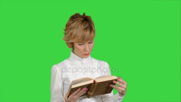 Konzentrierte junge Geschäftsfrau hält und liest Buch auf grünem Bildschirm, Chroma-Schlüssel — Stockvideo